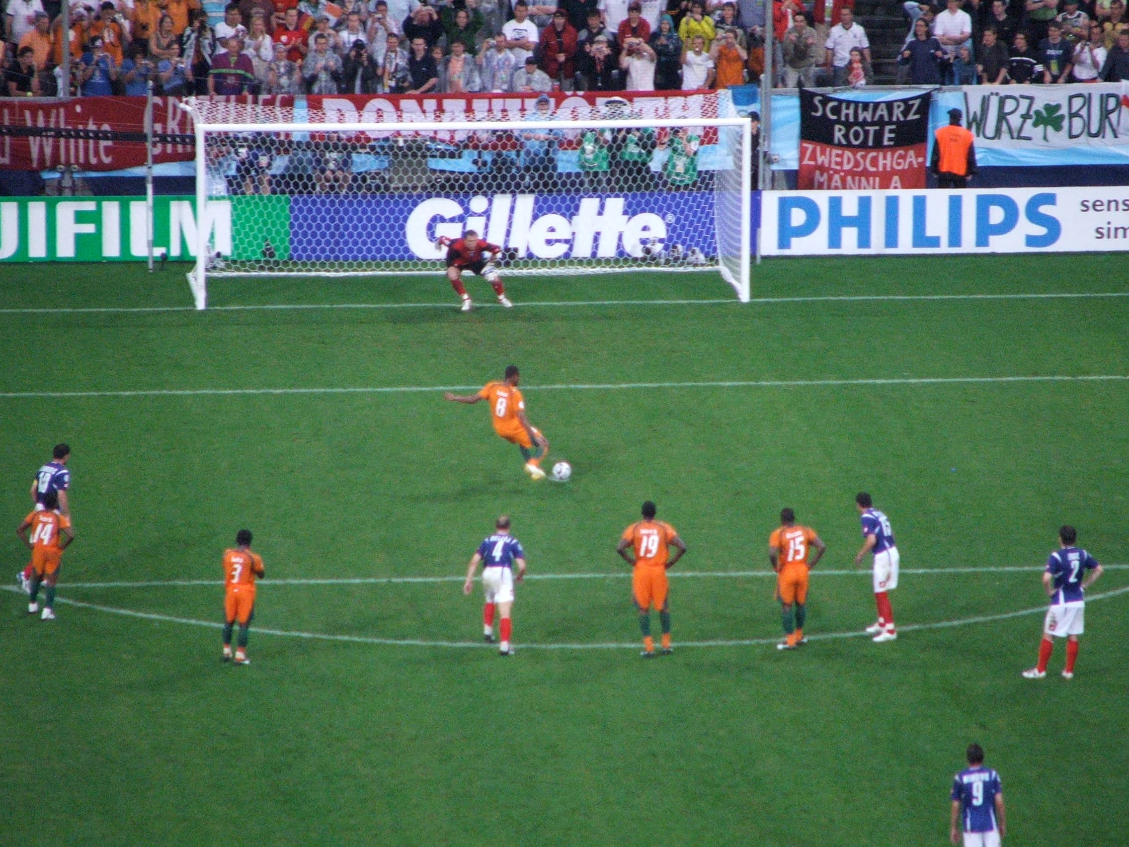 Penalty kick being taken at a World Cup match with the goalkeeper set on the goal line.